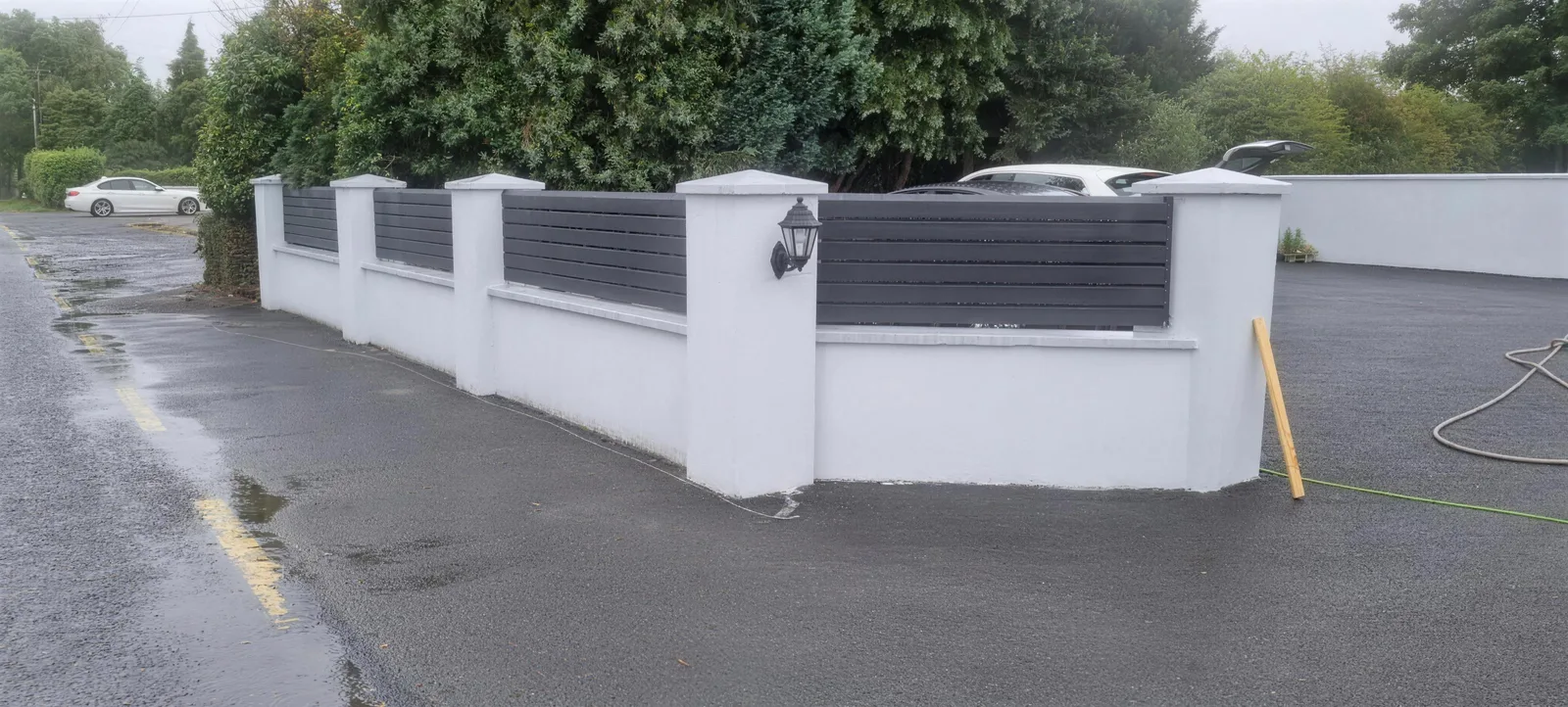 Rendered pillar wall with grey slat panels and lantern